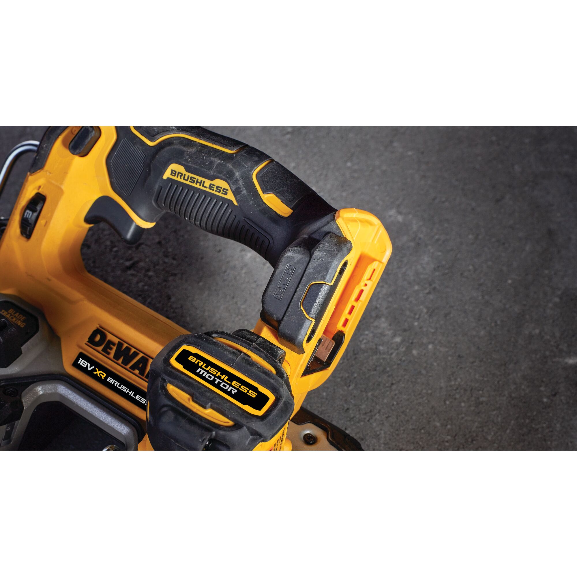 Close-up view of a DEWALT cordless power tool with yellow and black brushless motor details, showing part of the handle and battery pack against a dark surface.