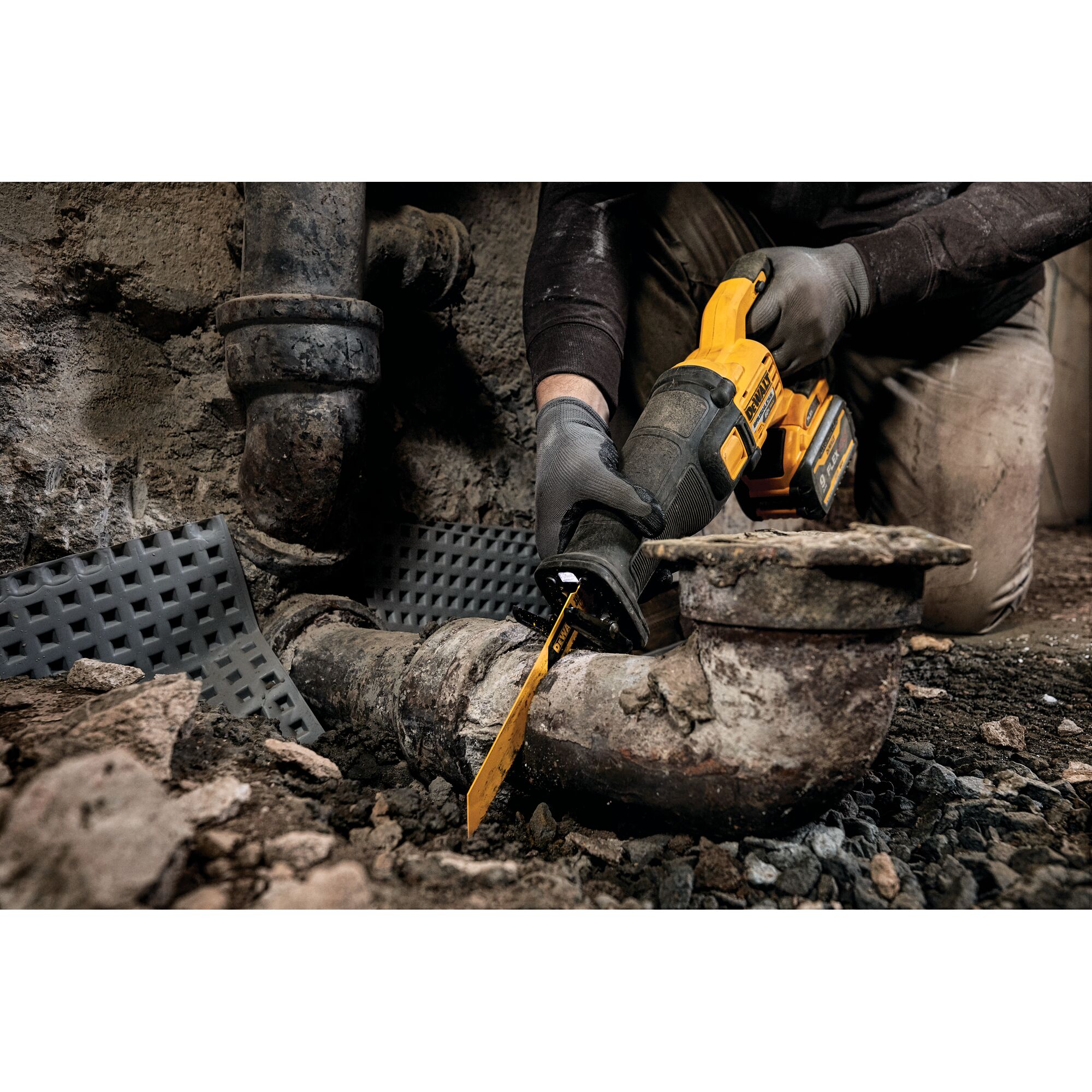 FLEXVOLT brushless cordless reciprocating saw being used to cut drainage pipe.