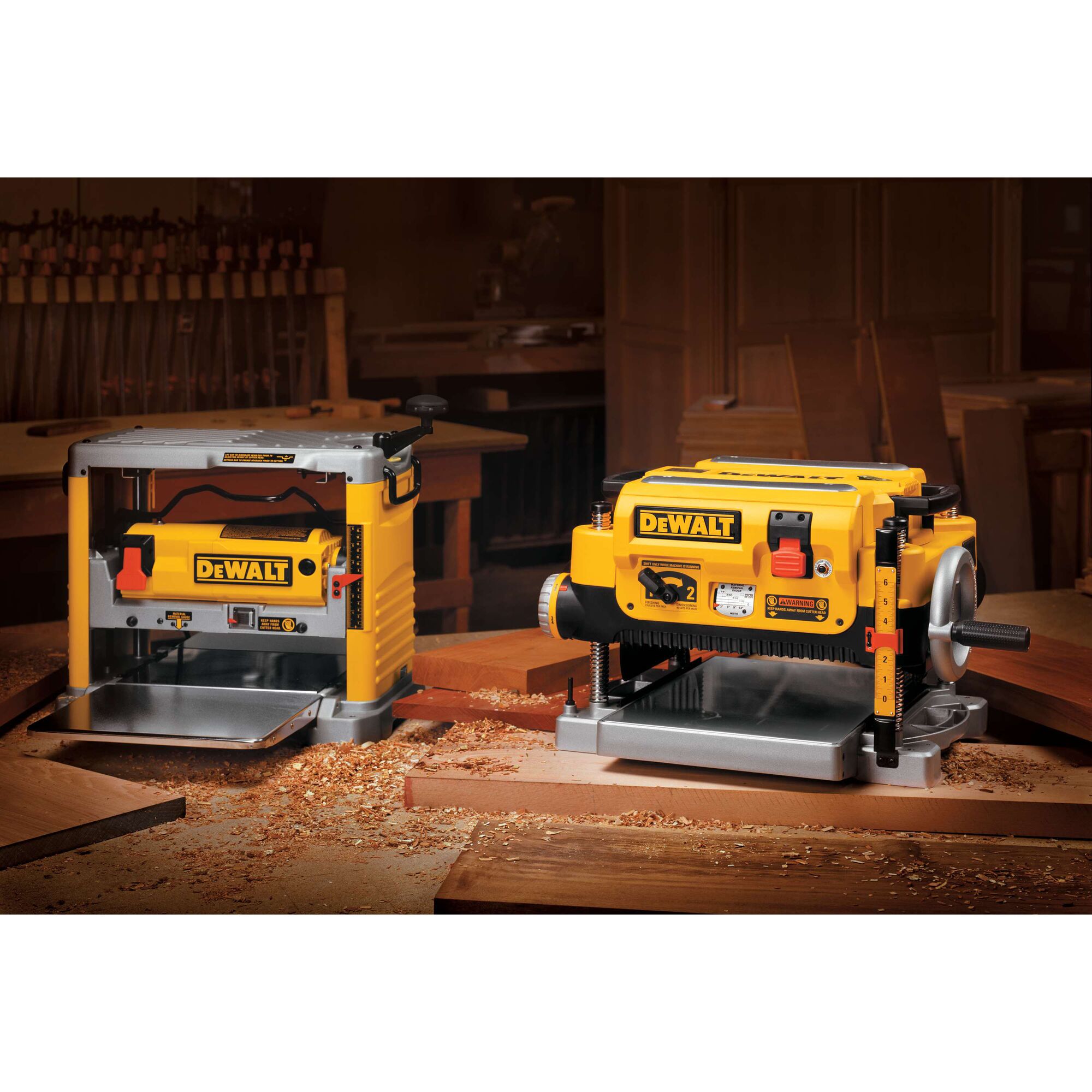 Two yellow DEWALT DW735 woodworking planers placed on a workbench in a woodshop, surrounded by wood shavings and wooden boards.