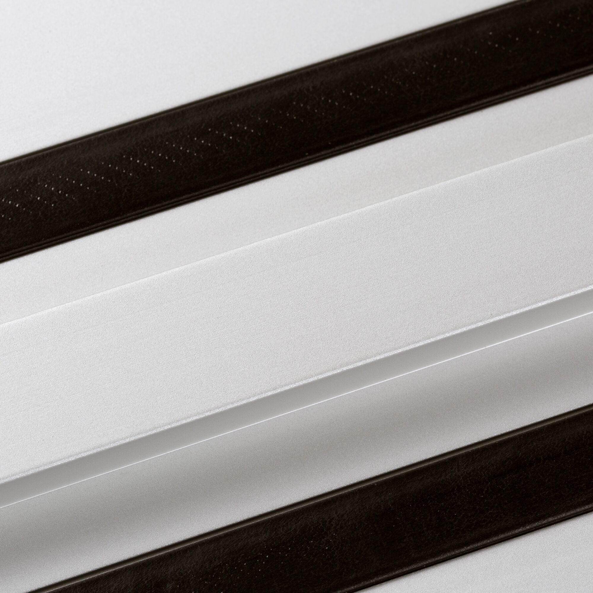 Close-up image of a DEWALT guide rail, showing two parallel black strips on a white or metallic surface. The product is used for precise guiding of power tools such as saws.