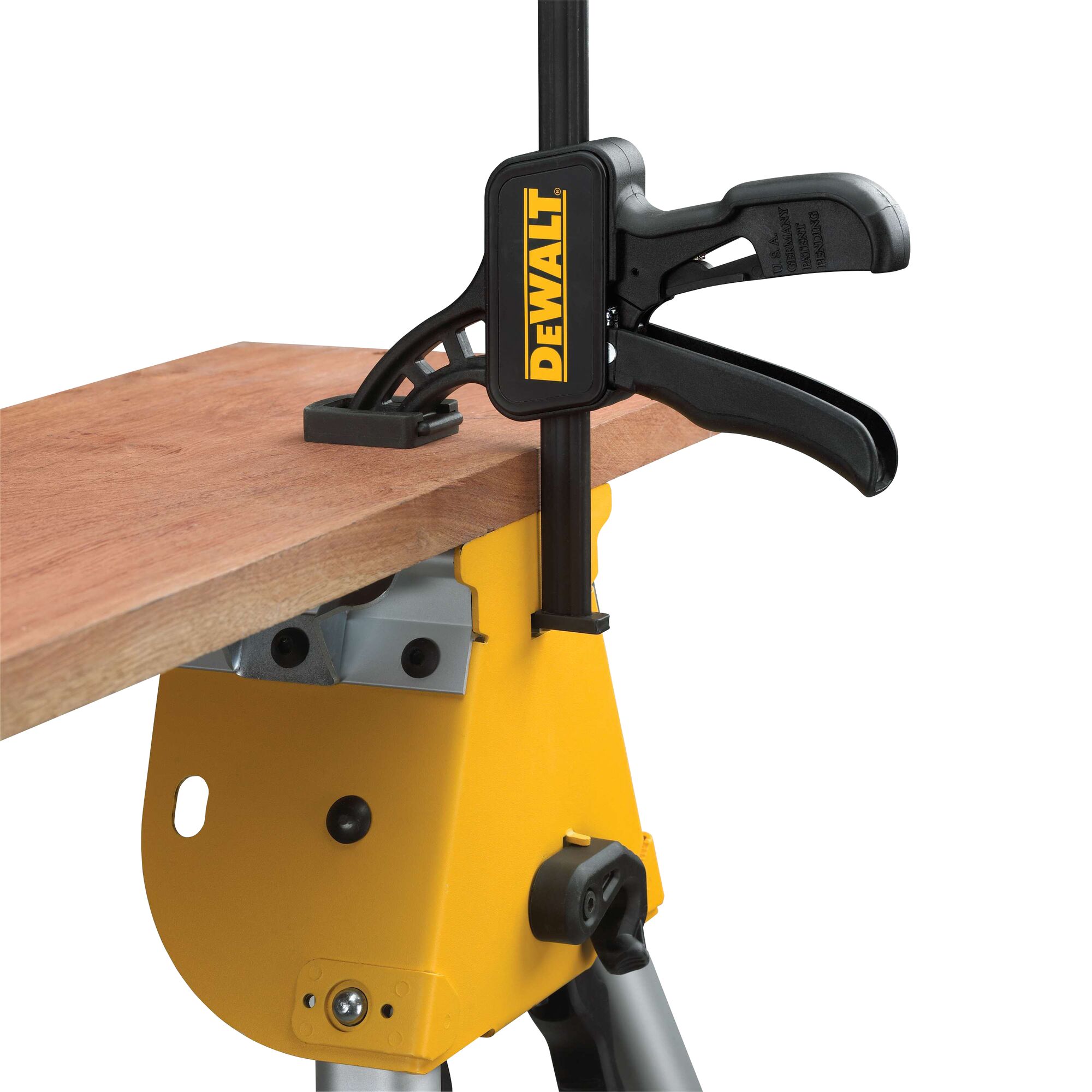 DEWALT clamp secures a wooden board to a yellow workbench for stability during cutting or assembly.